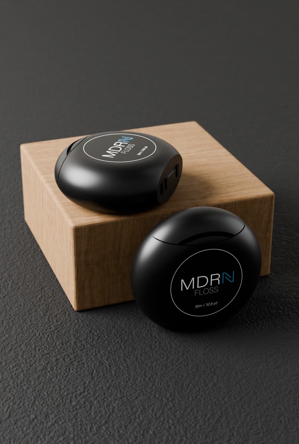 Two floss containers displayed on a wood block