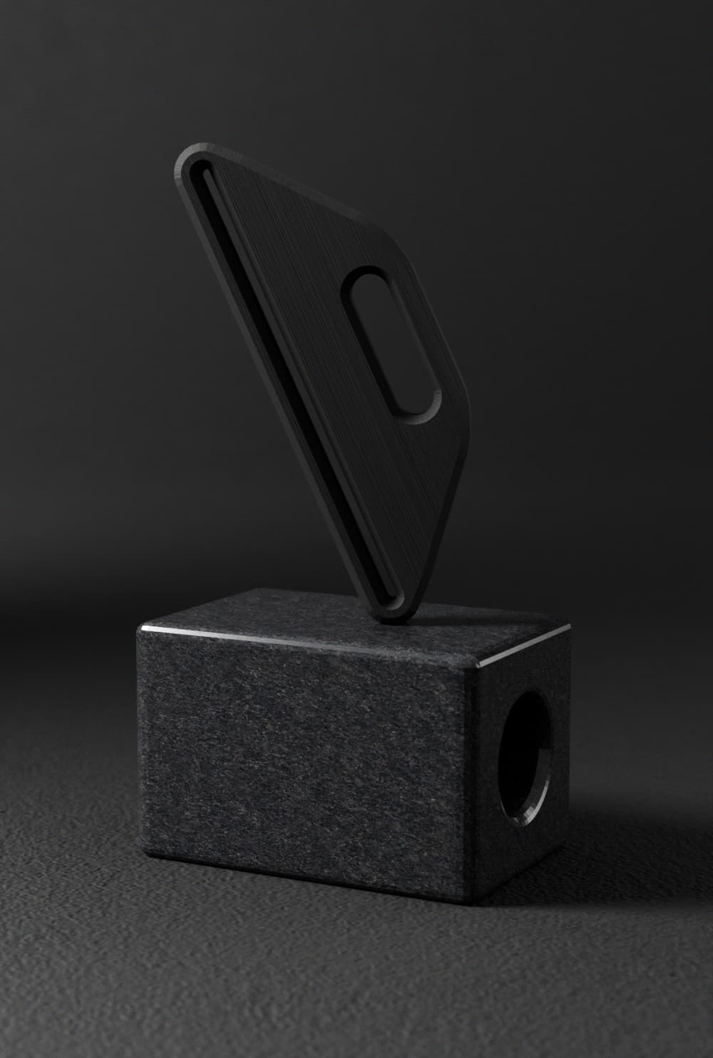 Black toothpaste squeezer displayed on a stone block